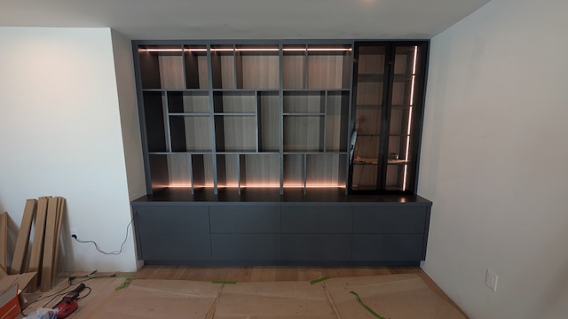 Custom library wall with glass doors and lighting by JSG Cabinets